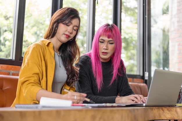 Hombre transgénero LGBTQ Hermoso especialista auténtico con cabello rosado y trans no binario trabajando juntos Diseño de trabajo en un lugar de trabajo creativo colegas de trabajo en equipo Igualdad de género