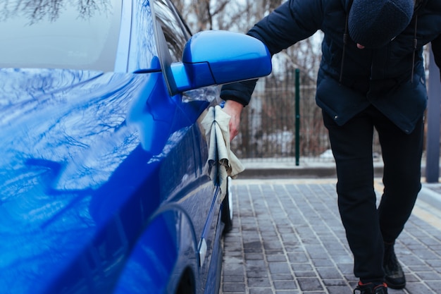 Un hombre con un trapo para secar el coche. concepto de lavado de autos