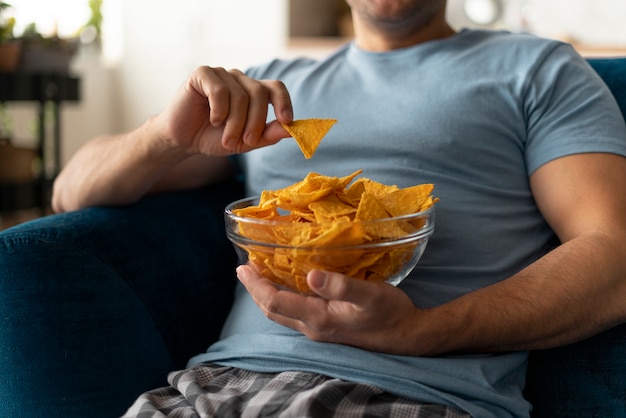 Foto hombre con trastorno alimentario tratando de comer patatas fritas