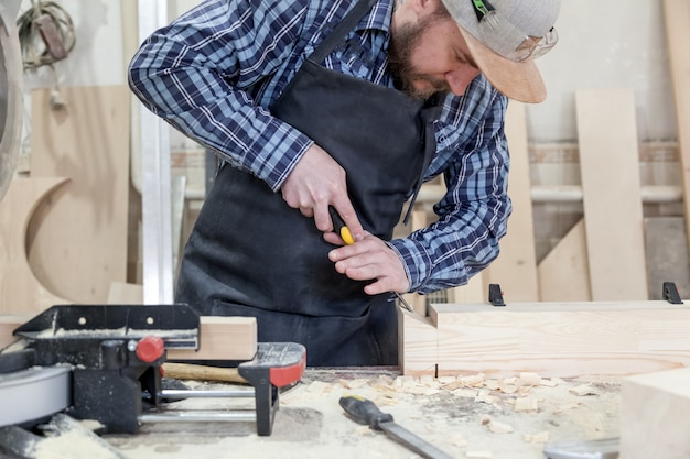 Hombre tratando un producto de madera con un cincel.