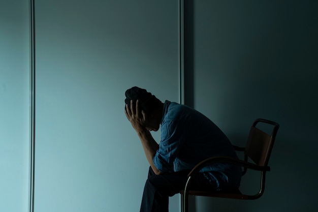 Hombre triste en la cama en la habitación oscura trastorno depresivo mayor