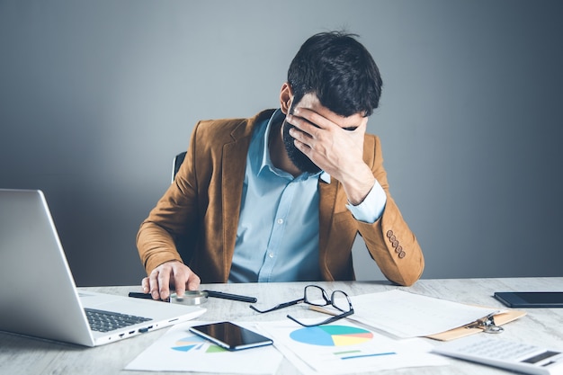 Hombre triste de la mano en el escritorio de oficina