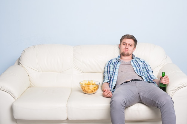 Hombre triste o aficionado al fútbol viendo fútbol en la televisión