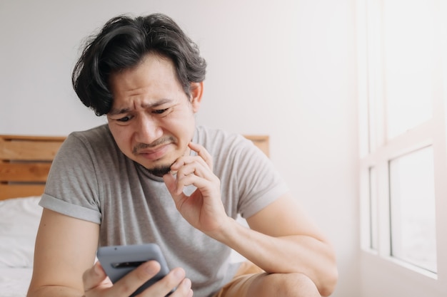 El hombre triste tiene malas noticias de chat en línea y se siente decepcionado con el teléfono inteligente