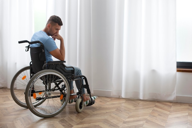 Foto hombre triste de tiro completo en silla de ruedas