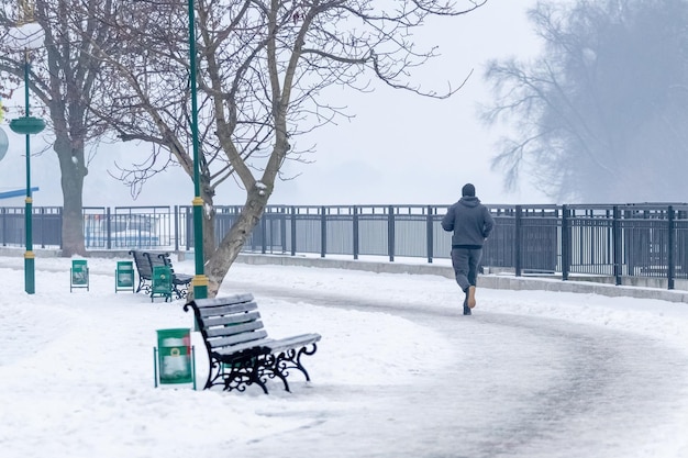Hombre trotando en el estilo de vida saludable del parque de invierno