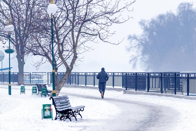 Hombre trotando en el estilo de vida saludable del parque de invierno