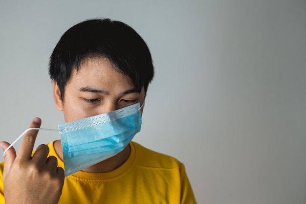 El hombre tuerce las correas de la máscara médica Este método ayuda a mejorar el ajuste y la filtración de la máscara Protección pandemia mundial de coronavirus Otro nombre de esta enfermedad se llama COVID19
