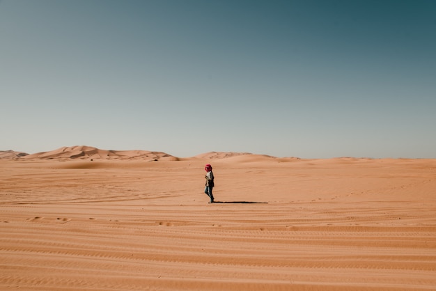 Hombre en turbante caminando solo en el desierto