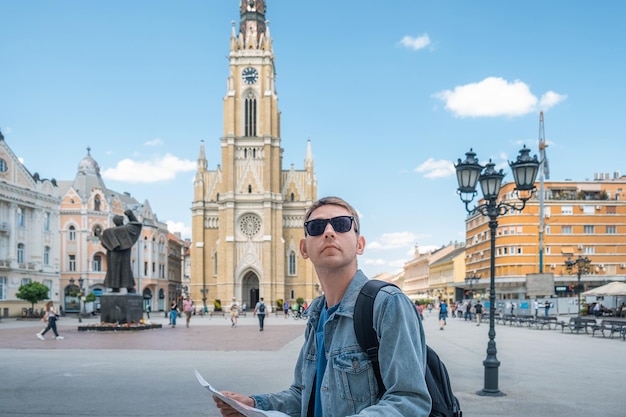 Hombre turista con mapa turístico de pie al aire libre en el retrato de la ciudad vieja de un hombre guapo