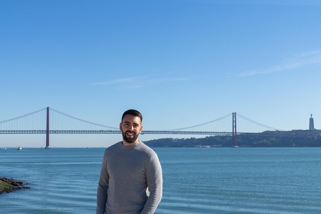 Hombre turista y puente 25 de abril al fondo