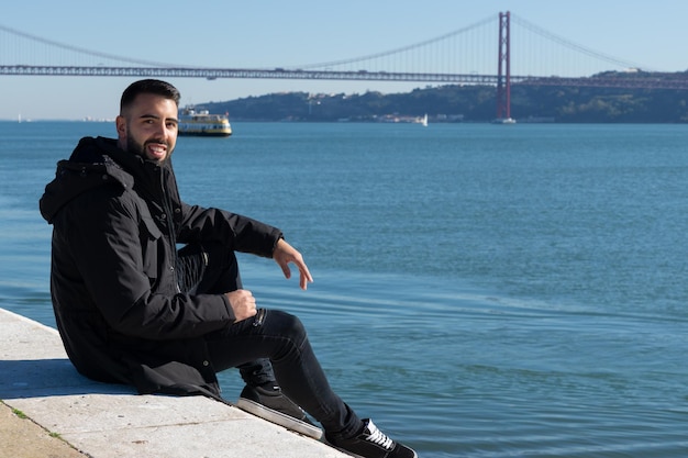 Hombre turista y puente 25 de abril al fondo