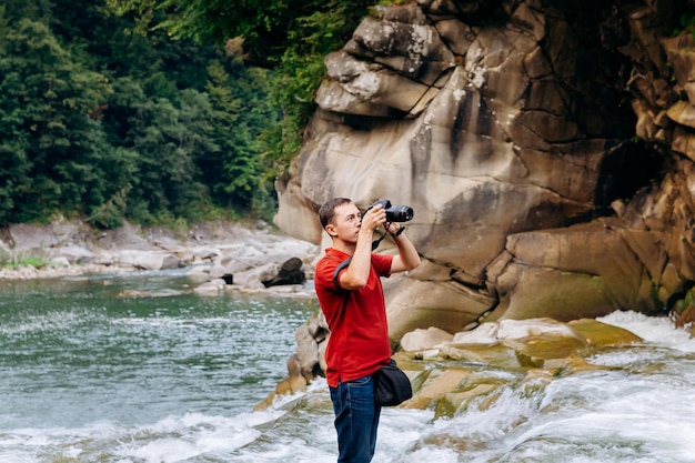 Hombre turista toma fotografías del río de montaña Prut y cascada Probiy en Yaremche Cárpatos Ucrania