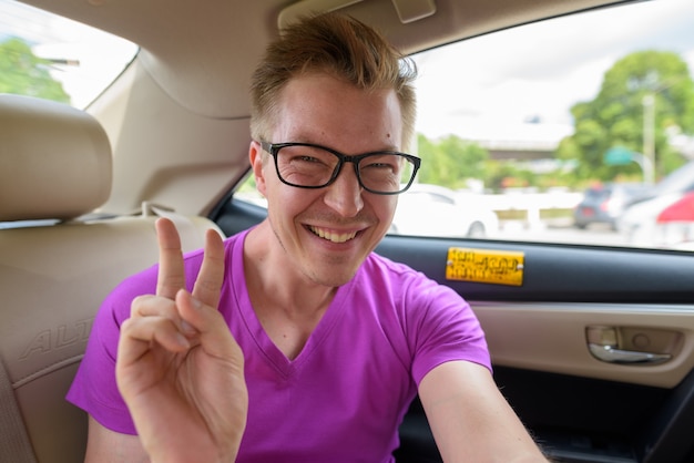 Hombre turista tomando selfie en el asiento trasero de un taxi en Bangkok, Tailandia