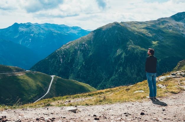 Hombre turístico de pie en la cima de la montaña