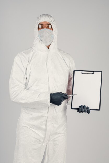 Un hombre con uniforme y mascarilla sosteniendo un cartel Concepto de salud y medicina