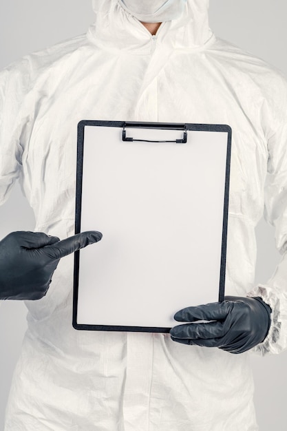 Un hombre con uniforme y mascarilla sosteniendo un cartel Concepto de salud y medicina