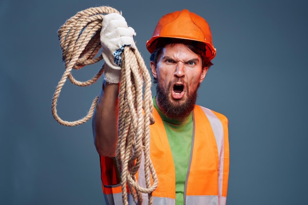 Foto un hombre con un uniforme de trabajo con una cuerda en las manos emociones estilo de vida de construcción foto de alta calidad