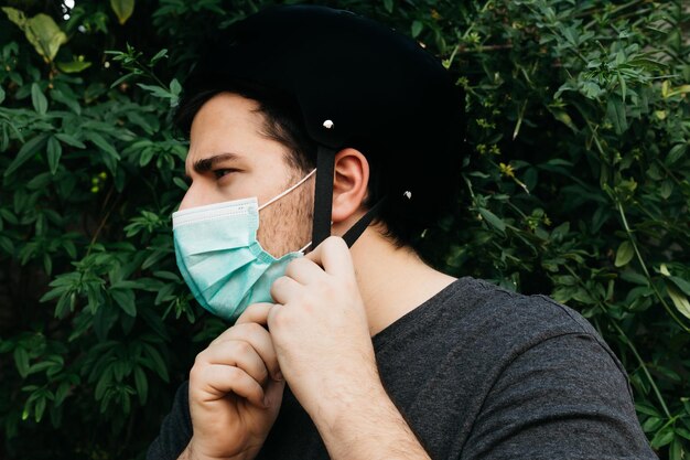 El hombre usa un casco de bicicleta con una máscara médica para estar seguro