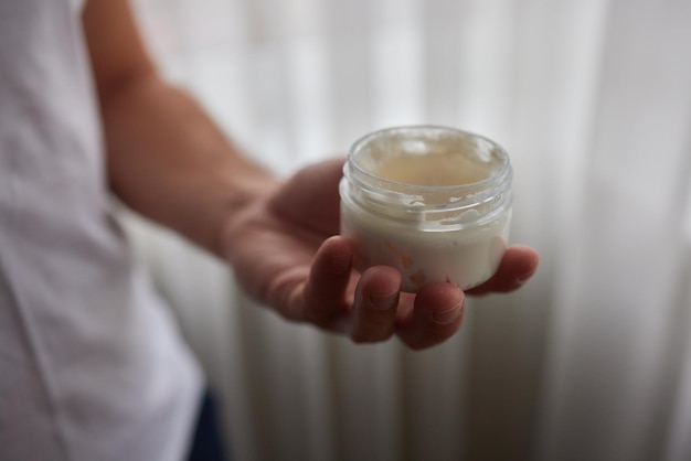 El hombre usa crema de manos para cerrar las manos de los hombres tonificados