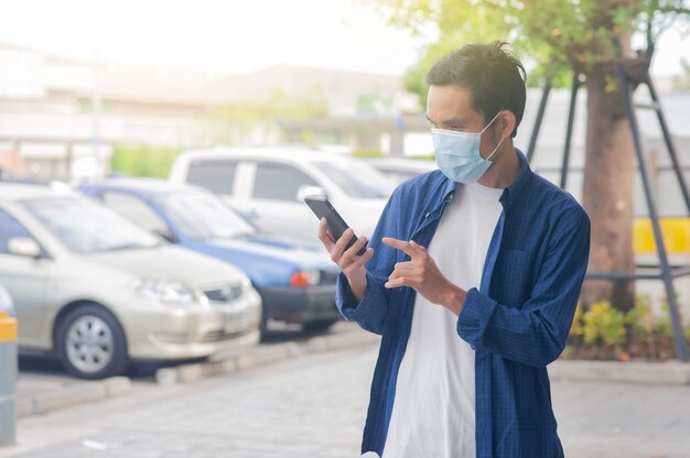 Hombre usa mascarilla con teléfono inteligente móvil