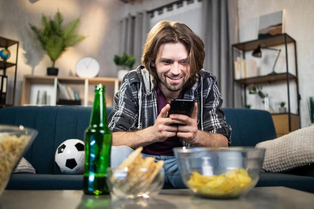 Hombre usando un aparato para ver la transmisión en vivo del partido de fútbol