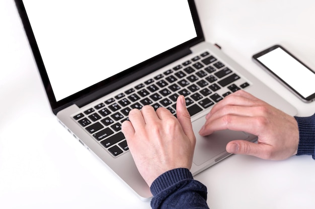 hombre usando una computadora portátil moderna en una mesa blanca