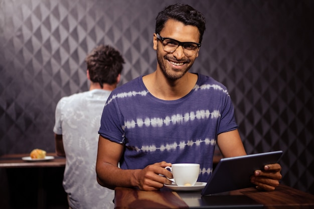 Hombre usando una computadora portátil y tomando café