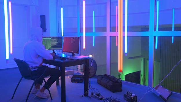 Hombre usando computadoras en una habitación iluminada