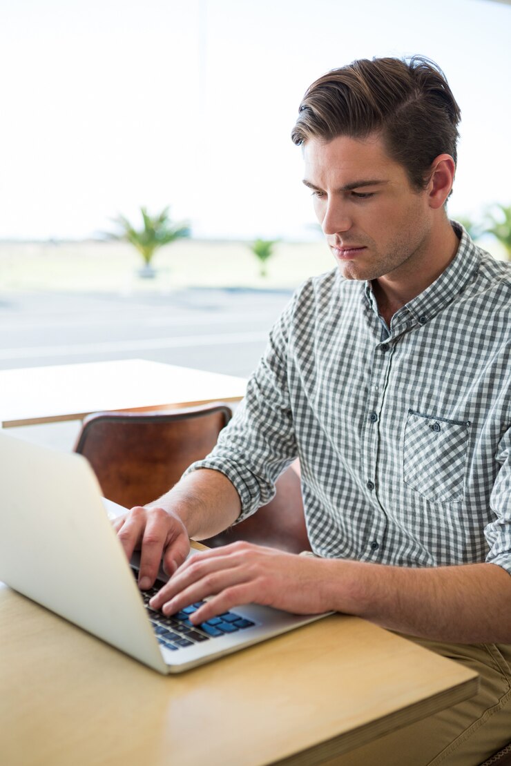 Foto hombre usando laptop en cafetería