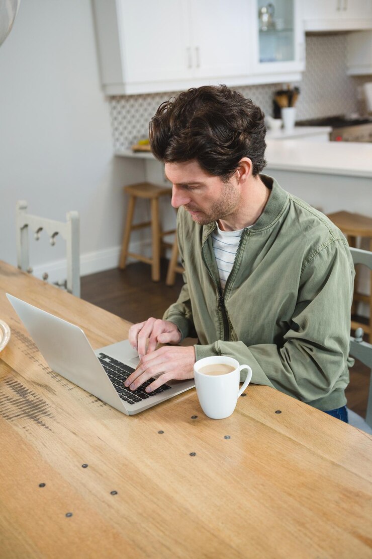 Foto hombre usando laptop en cocina