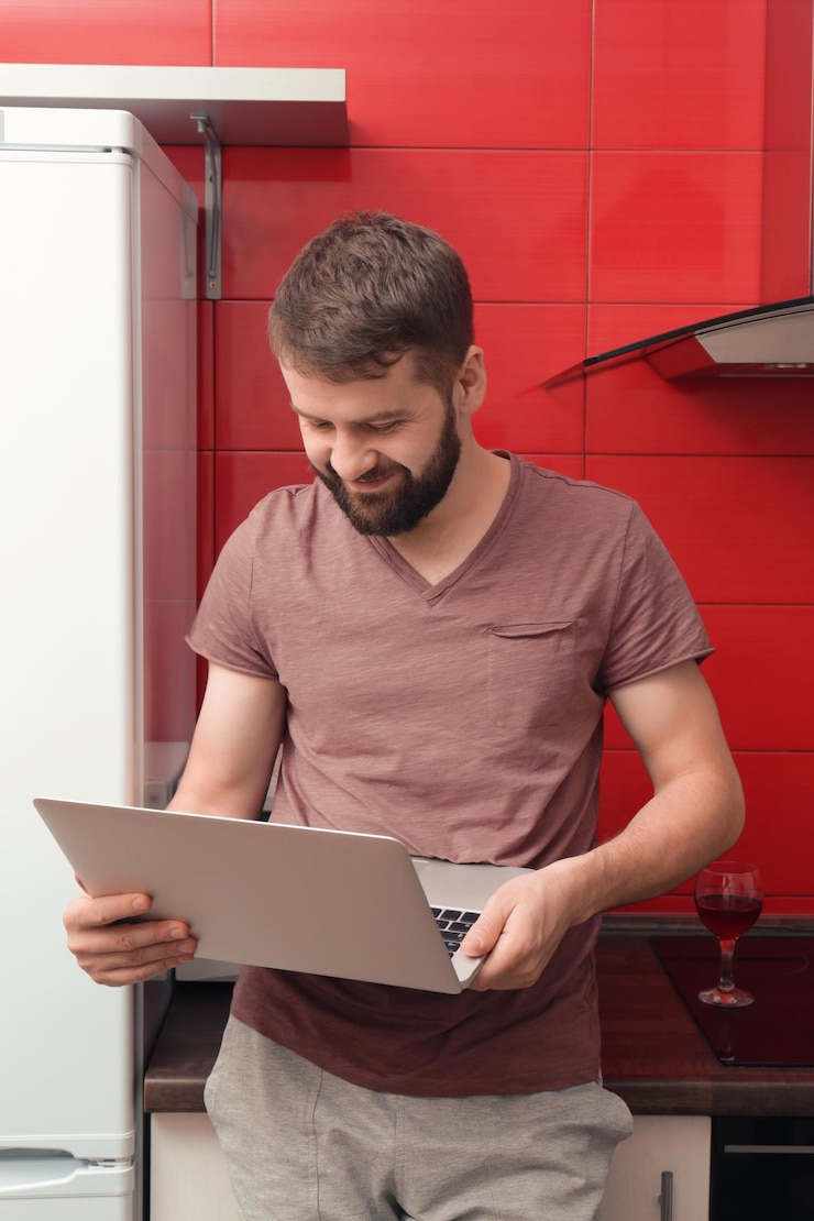 Foto hombre usando laptop en cocina