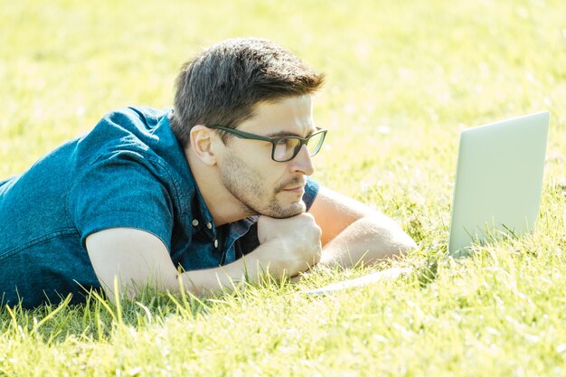 Hombre usando laptop en el parque de la ciudad