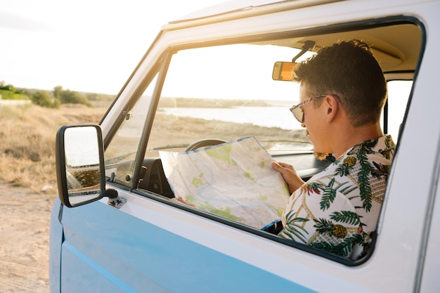 Hombre usando un mapa mientras conduce una autocaravana