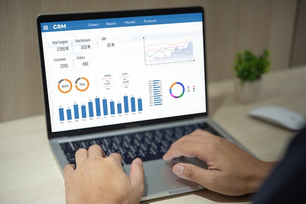 Hombre usando software de computadora portátil con gráficos y gráficos que muestran datos de ventas CRM Gestión de relaciones con los clientes Gestión de negocios Análisis de servicios Gestión de conceptos