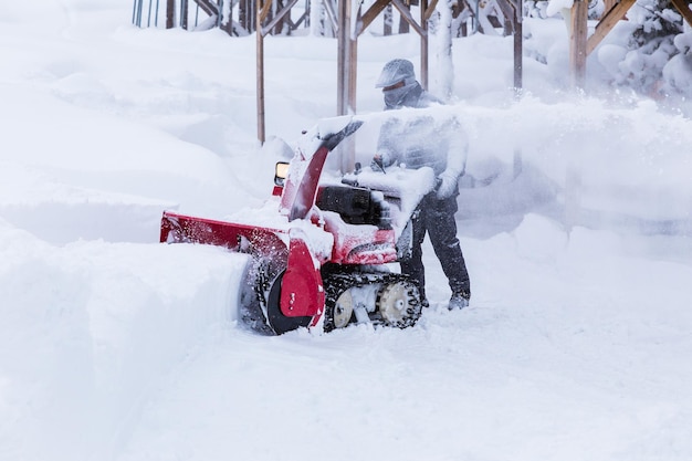 Un hombre usando un soplador de nieve para despejar el camino en un parque público