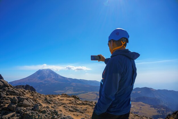 Hombre usando su teléfono celular en una montaña