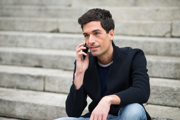 Hombre usando su teléfono móvil en un entorno urbano.