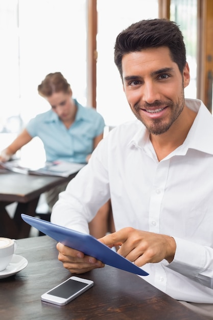 Hombre usando tableta digital en cafetería