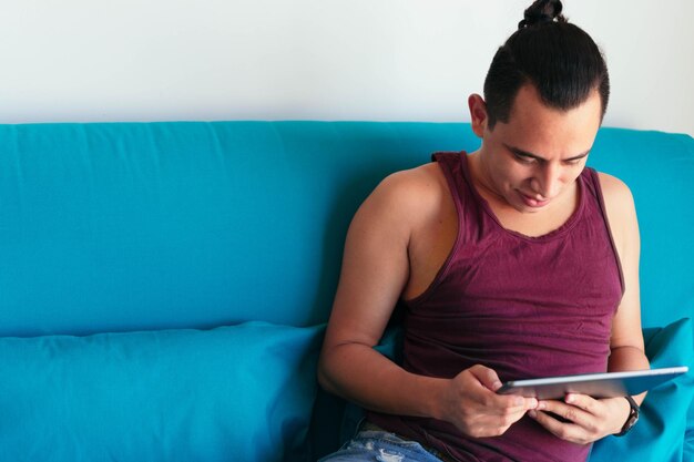 Hombre usando una tableta en el salón de su casa