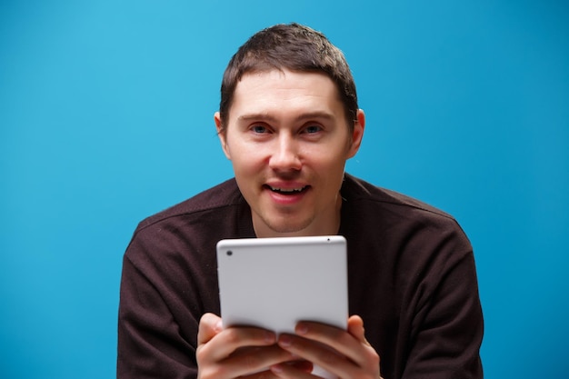 Hombre usando una tableta sobre fondo azul Concepto de redes sociales