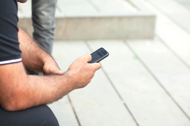 Hombre usando un teléfono inteligente en la calle