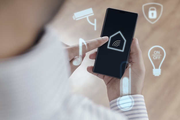 Hombre usando un teléfono inteligente para controlar el hogar inteligente