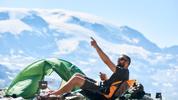 Hombre usando un teléfono inteligente en las montañas