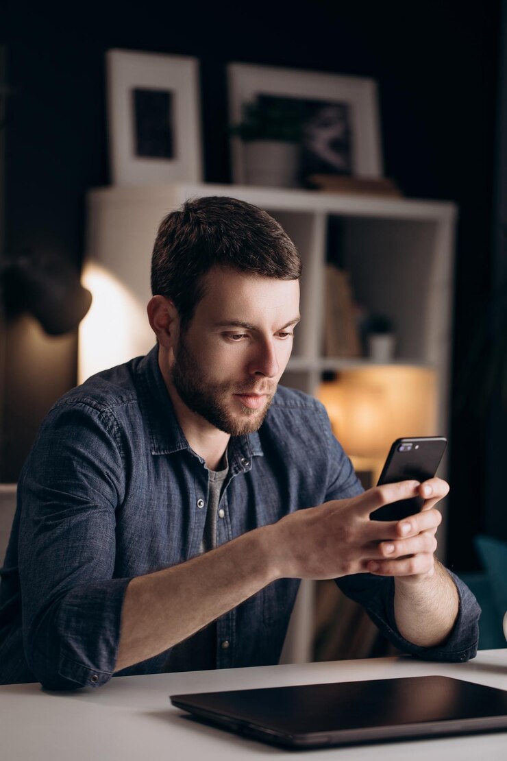 Hombre usando teléfono inteligente durante el tiempo libre en casa