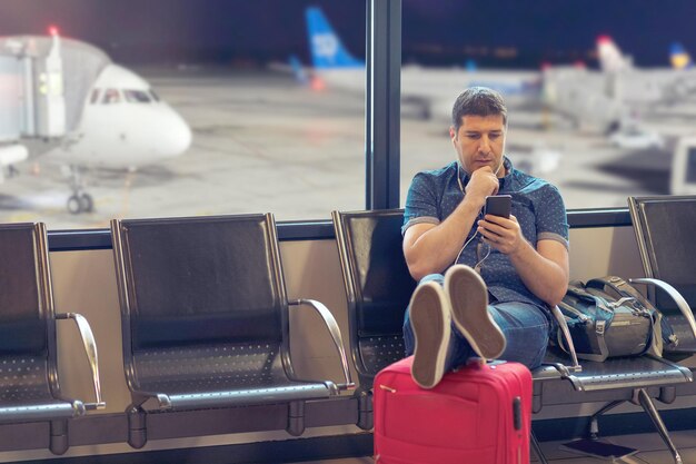 Hombre usando teléfono móvil en el aeropuerto