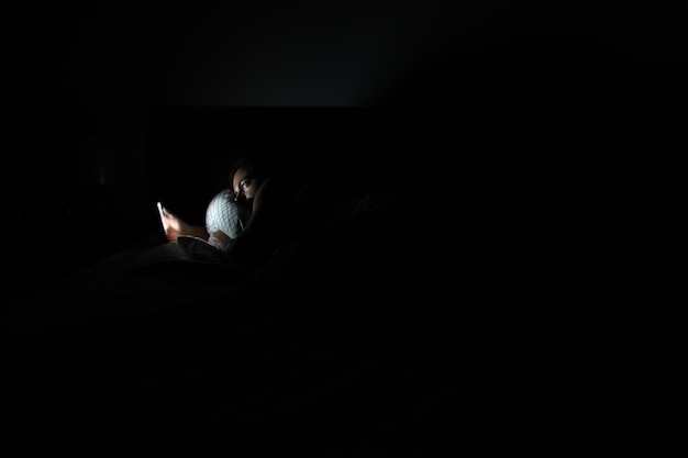 Foto hombre usando teléfono móvil en el cuarto oscuro