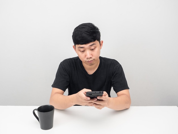 Hombre usando teléfono móvil en la mesa con taza de café