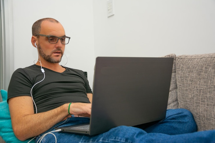 Foto hombre usando teléfono móvil mientras está sentado en el sofá