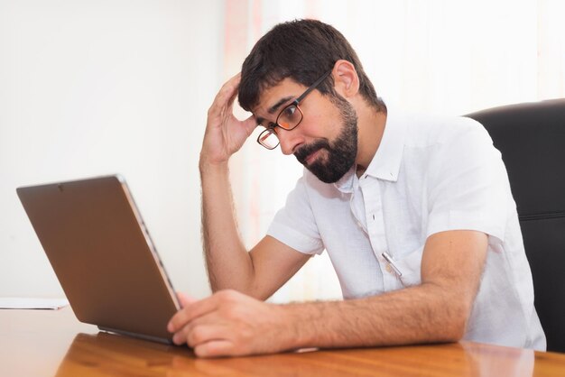 Foto hombre usando teléfono móvil mientras está sentado en la mesa